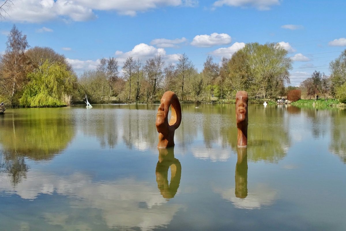 An abstract sculpture of wooden faces in the lakes