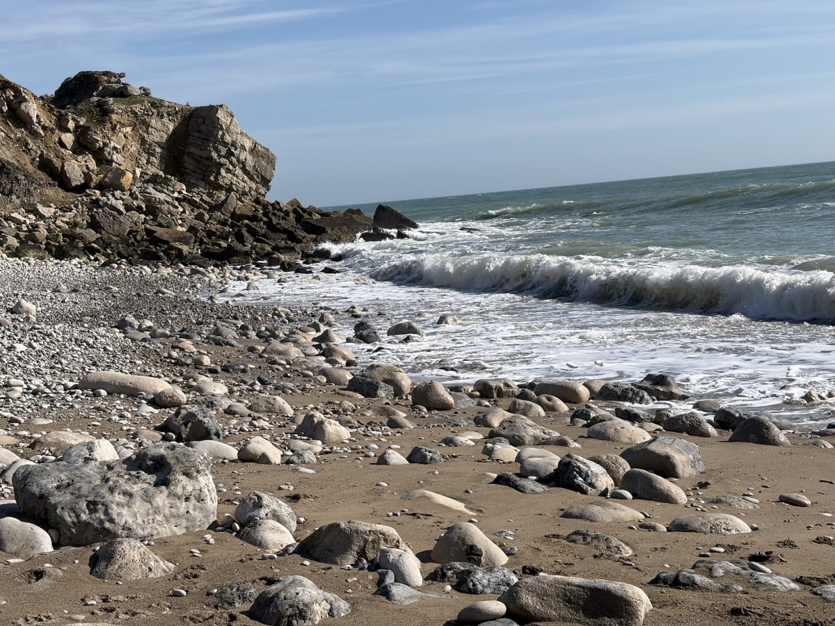 The rocky shoreline at Church Ope Cove, Portland, Dorset, waves, blue sky
