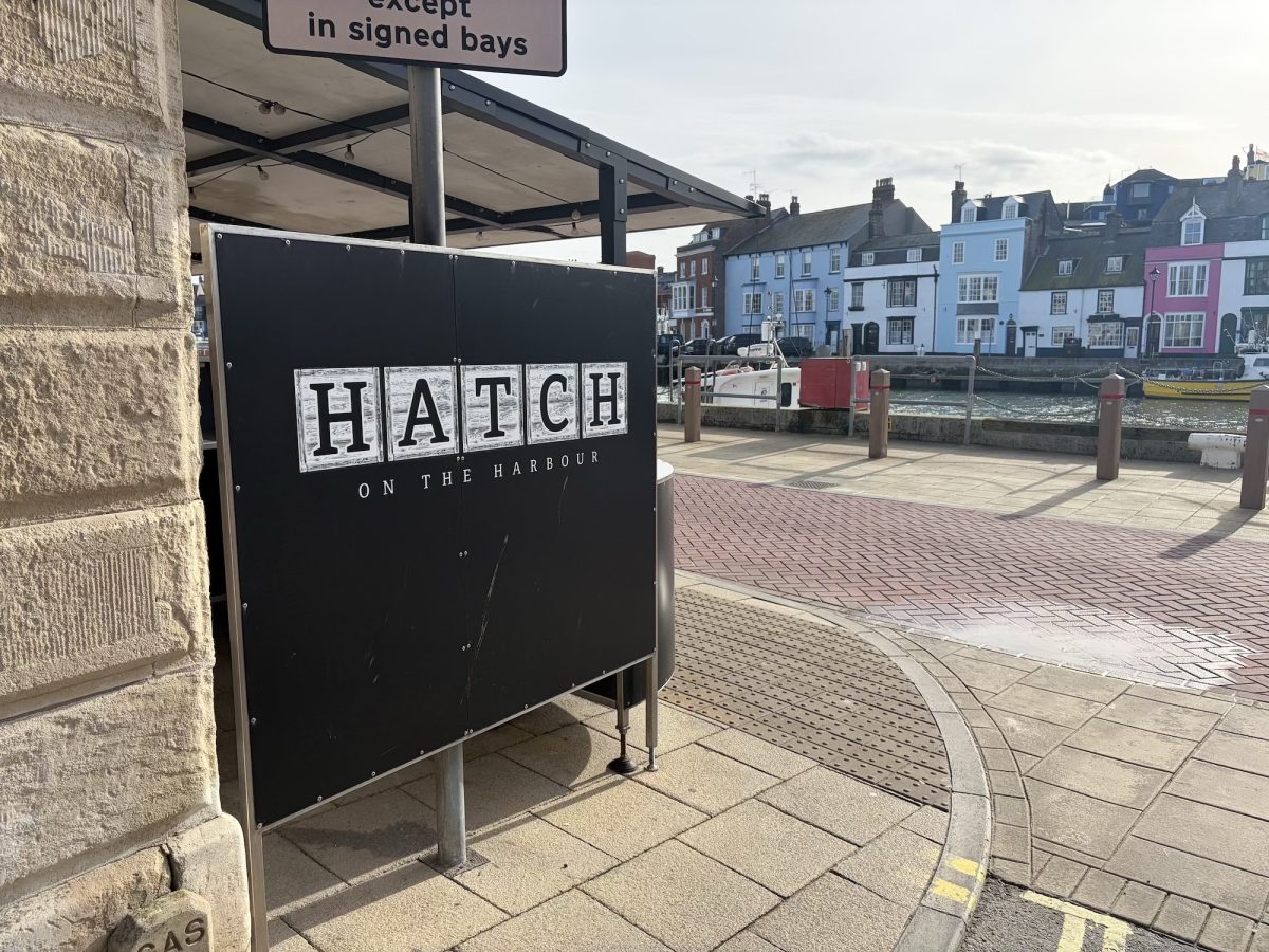 Exterior shot of The Hatch on The Harbour sign and waterside view