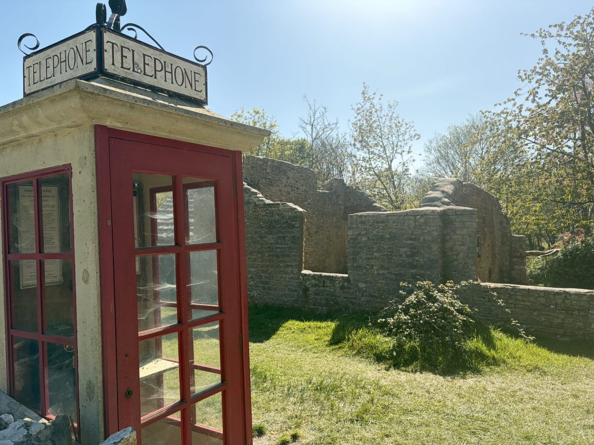 Old telephone box beside cottage ruins in Tyneham Village Dorset.