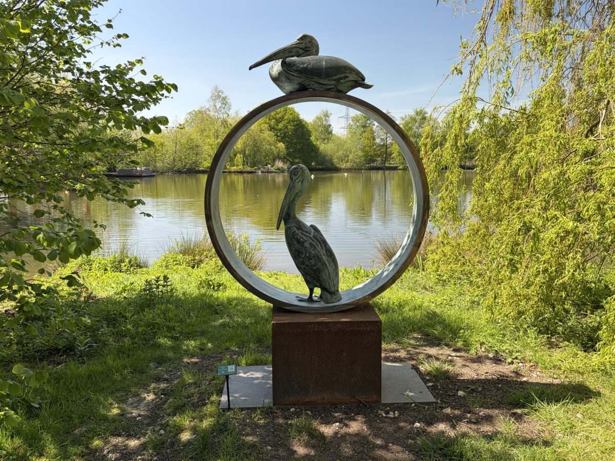 Circular sculpture with bird figures framing lake views at Sculpture By The Lakes near Dorchester, Dorset