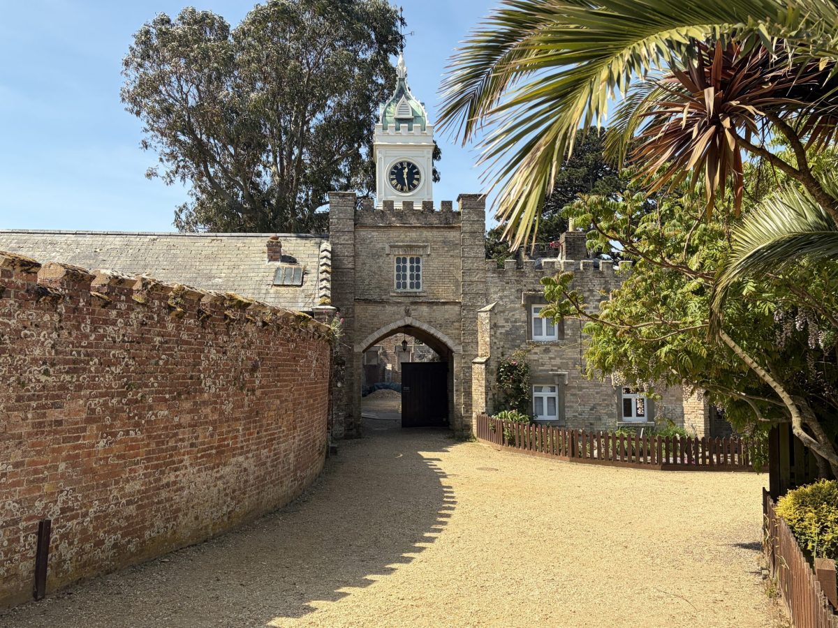 Palm tree and clock tower at the entrance to Brownsea Castle on Brownsea Island Dorset