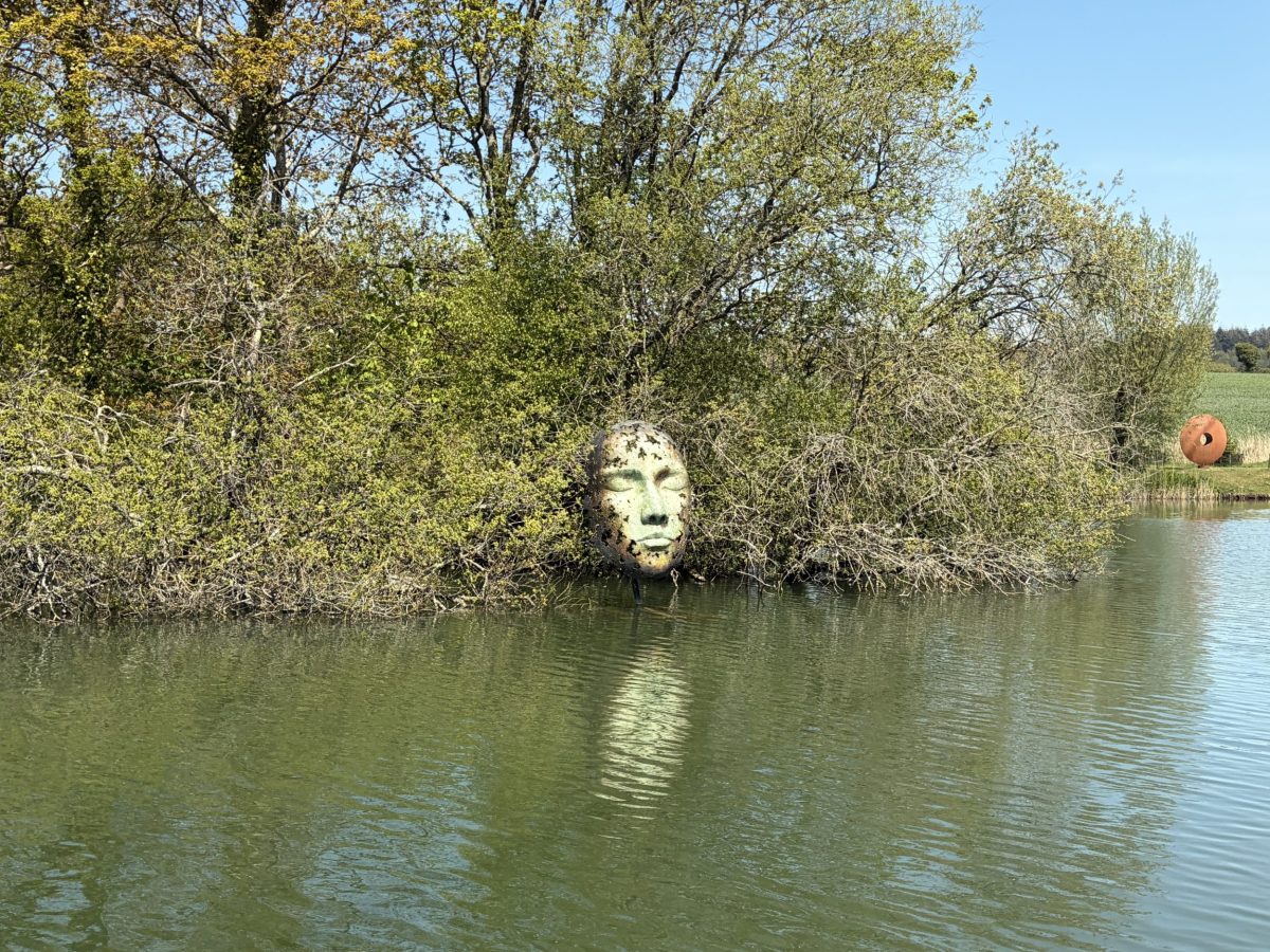 Large face sculpture overlooking the lake at Sculpture by The Lakes, near Dorchester, Dorset