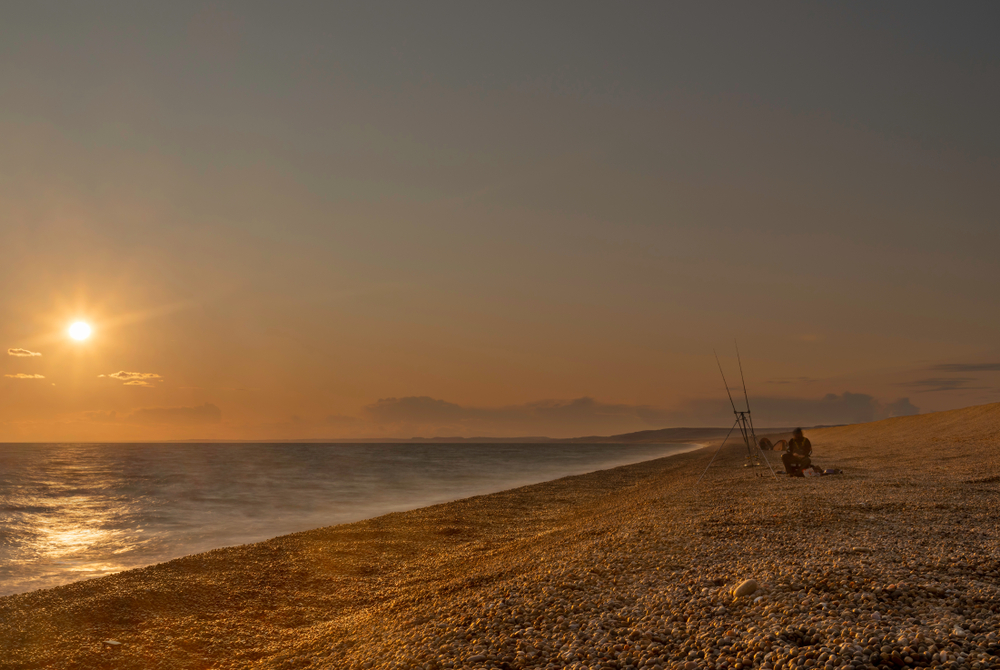 Sunset over Chesil Beach in Dorset, one of the county's most beautiful coastal dining locations