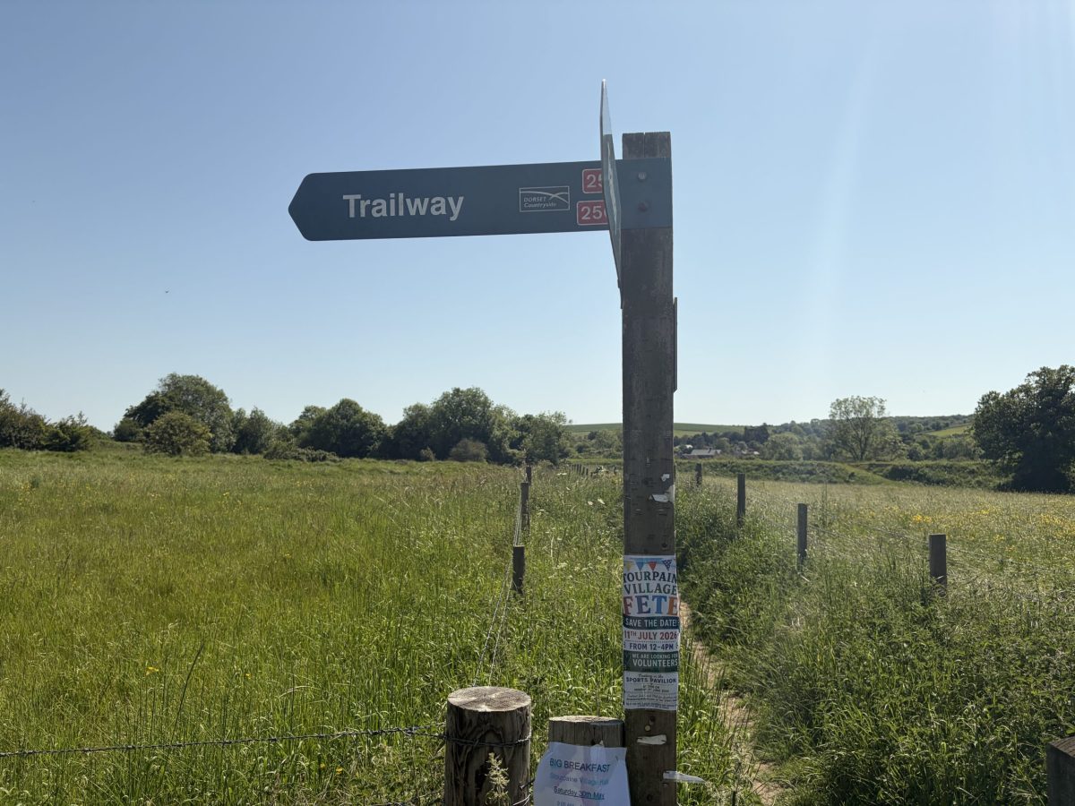 Wooden North Dorset Trailway sign in Stourpaine village, Dorset