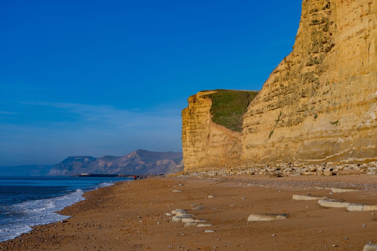 Golden sandstone cliffs beneath a blue sky at west Bay on Dorset's Jurassic Coast