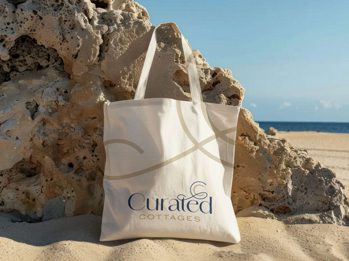 Curated Cottages beach bag on a Dorset beach representing our local knowledge and carefully chosen holiday cottages