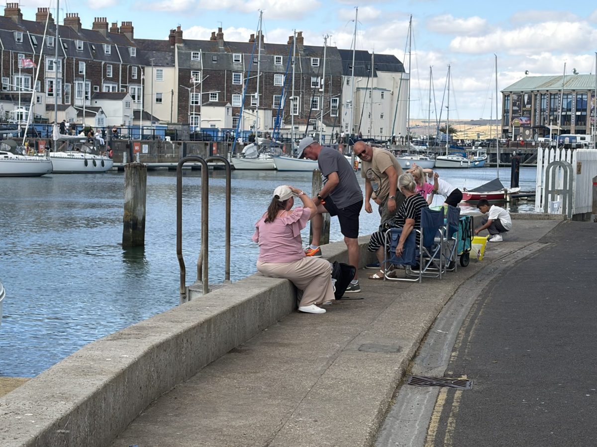 family crabbing from the harbour wall at Weymouth Harbour.