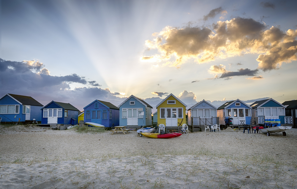 Colourful beach huts behind the sandy beach at Mudeford Spit in Dorset