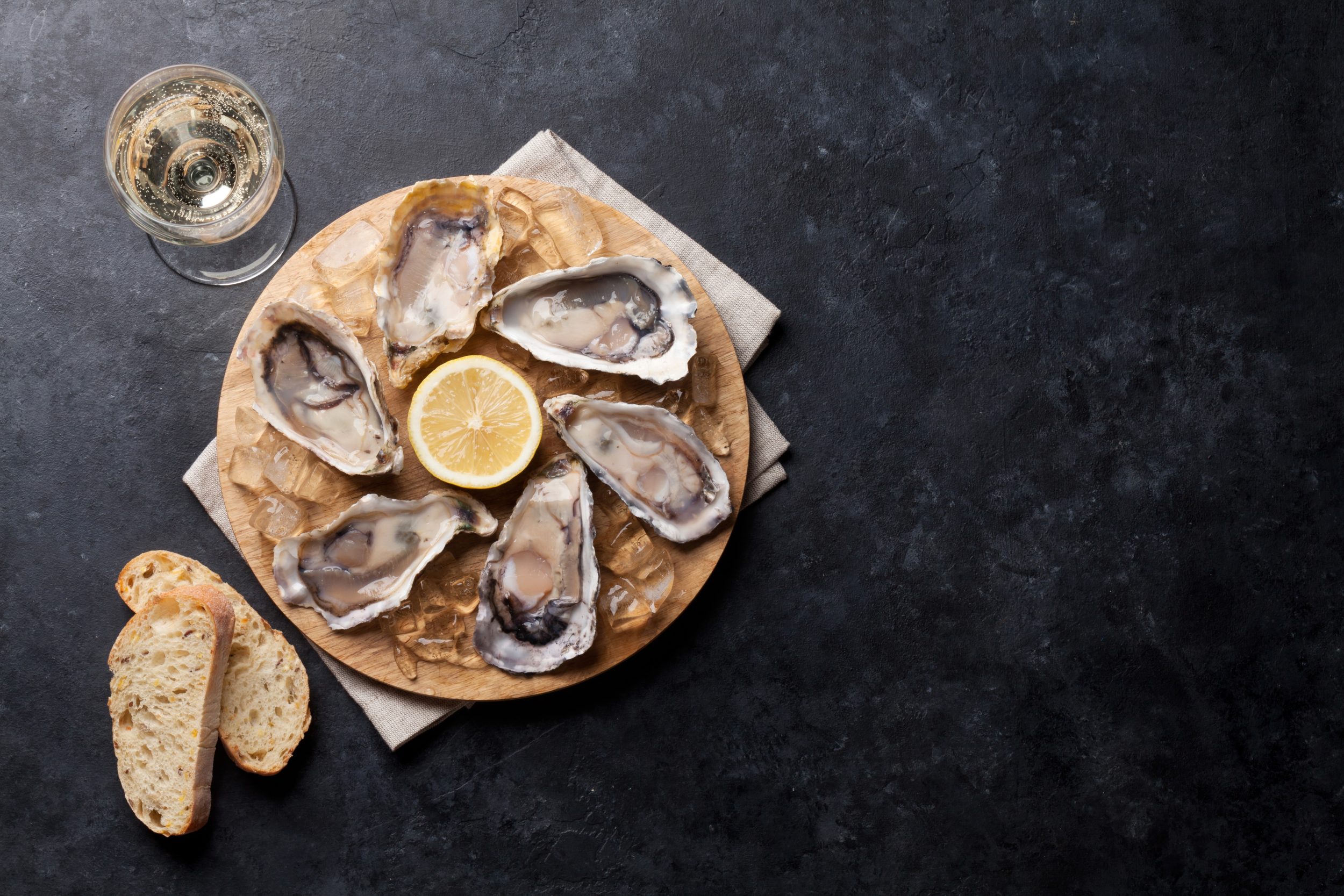 Fresh oysters, bread and a glass of white wine representing the excellent places to eat near Silverlake Estate in Dorset.