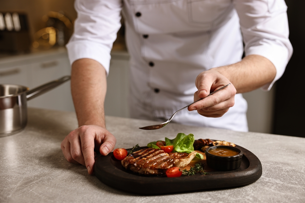 Private chef preparing a fine dining dish in a luxury holiday cottage