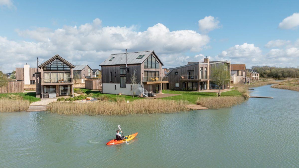 Aerial view of kayaking on the lake at Silverlake Estate with luxury waterfront cottages in the background.