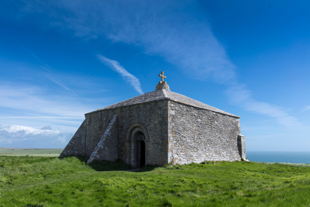 St Aldhelm's Chapel beneath blue skies at St Aldhelm's Head on Dorset's Jurassic Coast.