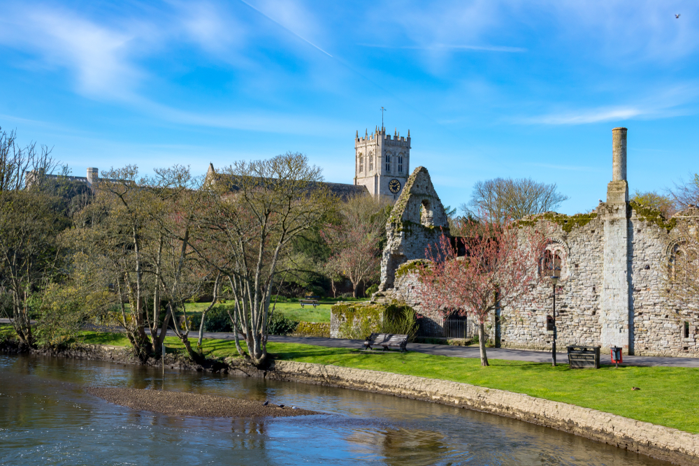 The Norman House Ruins and Castle Ruins at Christchurch in Dorset, beneath clear blue skies.