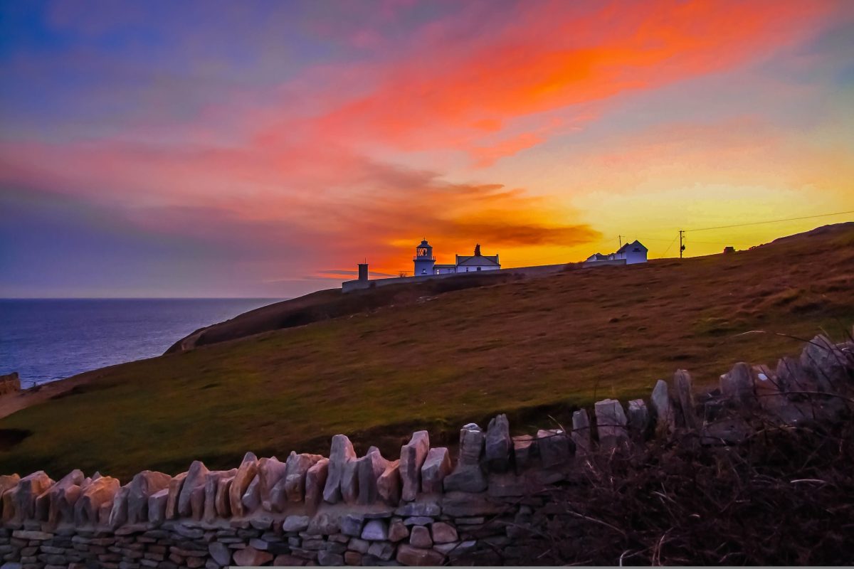 Durlston Lighthouse at sunset on the Swanage coastline along the Dorset Jurassic Coast
