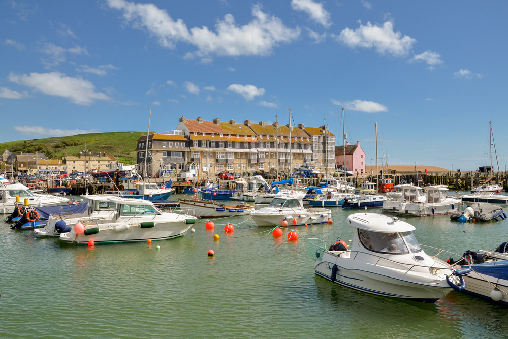 Traditional fishing boats moored in West Bay Harbour, one of the most popular attractions near Burton Bradstock, Dorset.