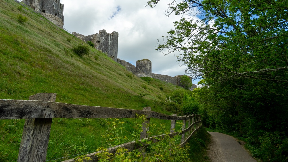 Footpath beneath Corfe Castle with the castle ruins visible above the Purbeck countryside