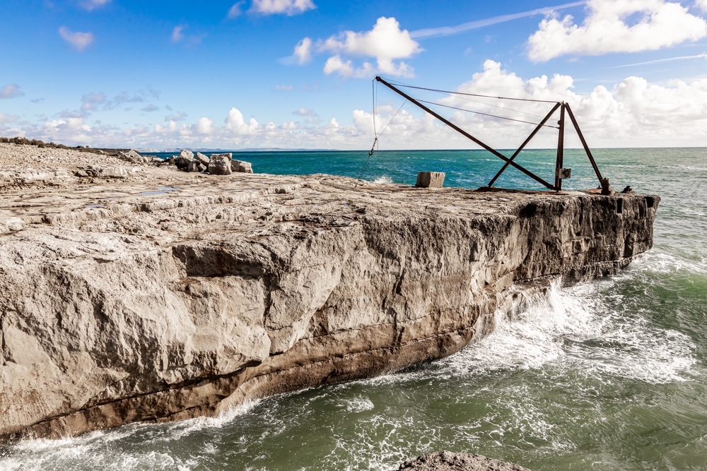 Rugged rocky coastline at Portland with waves crashing against the cliffs in Dorset.