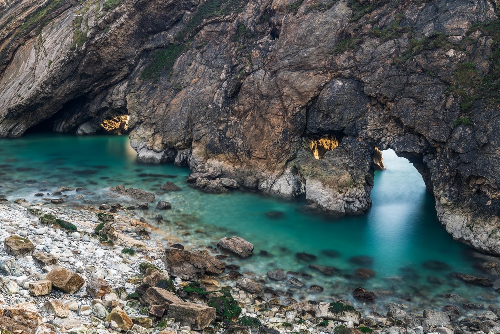 Close-up view of Stair Hole beside Lulworth Cove on the Dorset Jurassic Coast with clear blue sea