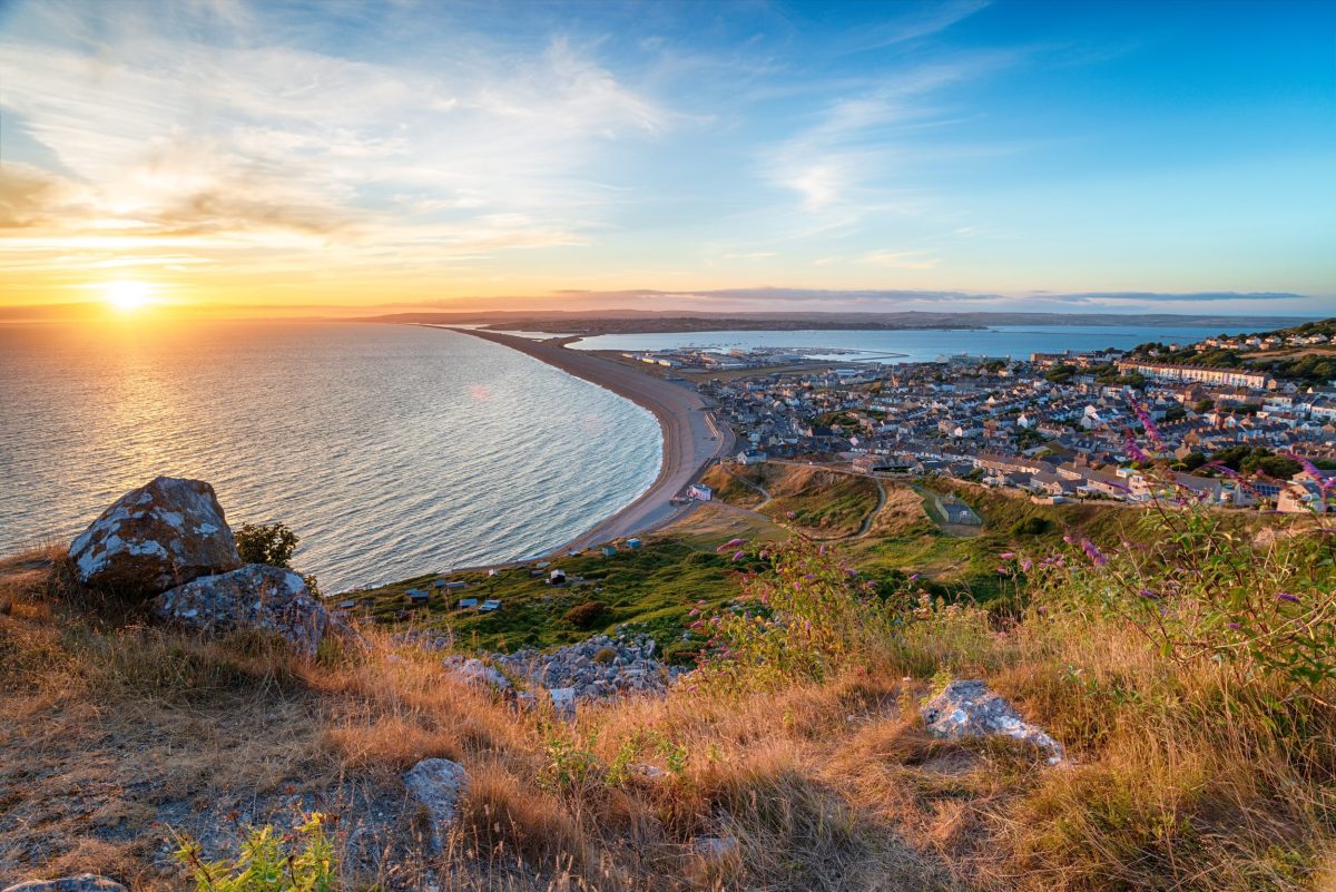 Sunset over Chesil Beach and the Isle of Portland viewed from the clifftops in Dorset.