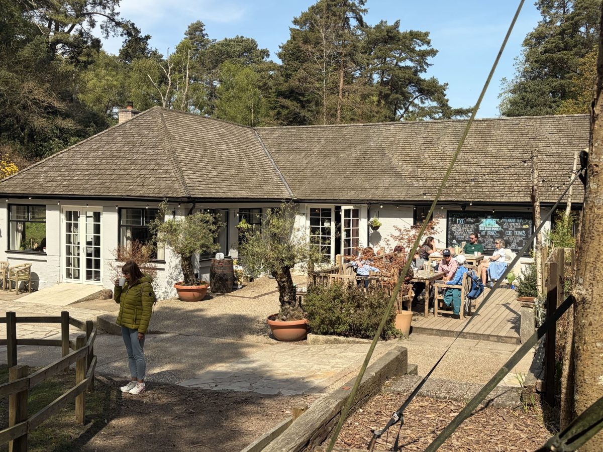 The outdoor seating area, and people sitting outside at the Blue Pool's tea rooms.