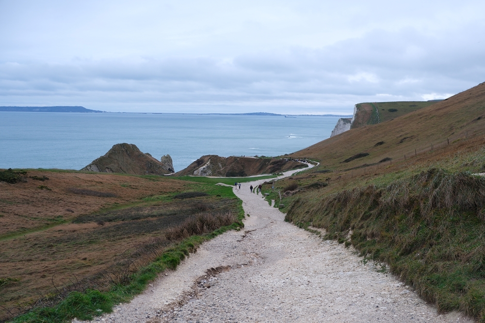 Walkers on the coastal path towards Durdle Door on the Dorset Jurassic Coast