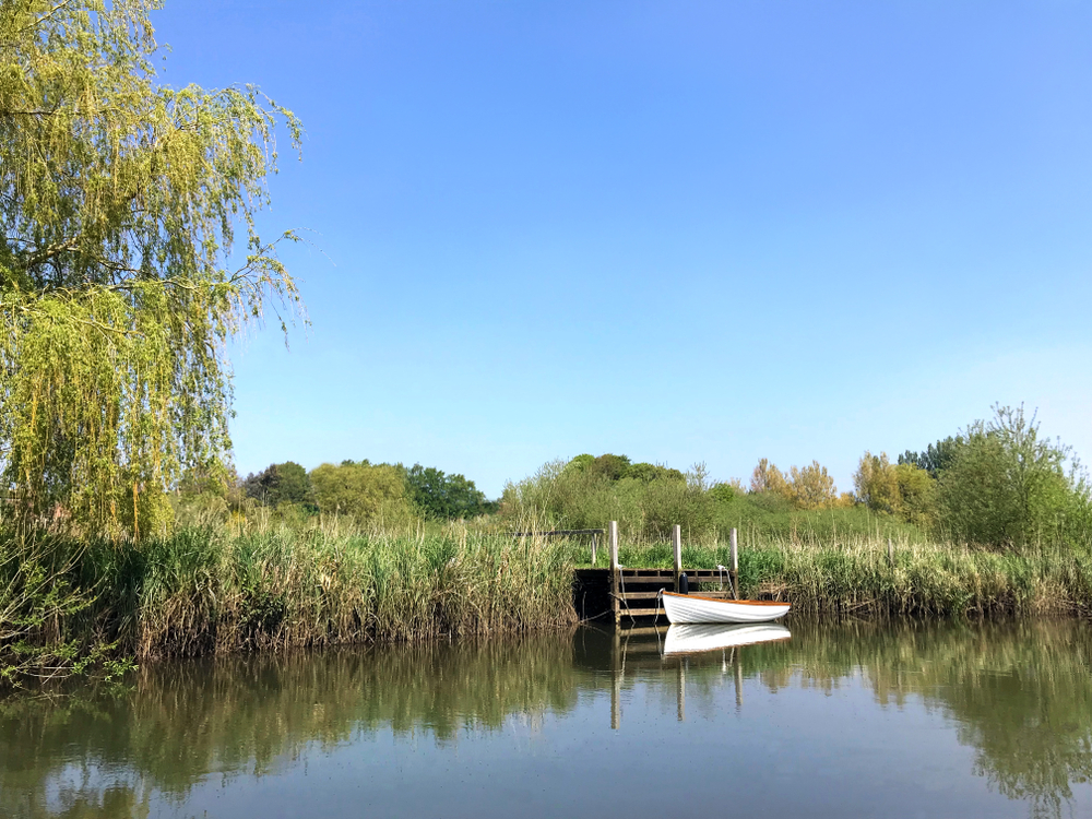 Traditional rowing boat moored on the River Frome beside the riverside footpath in Wareham, Dorset.