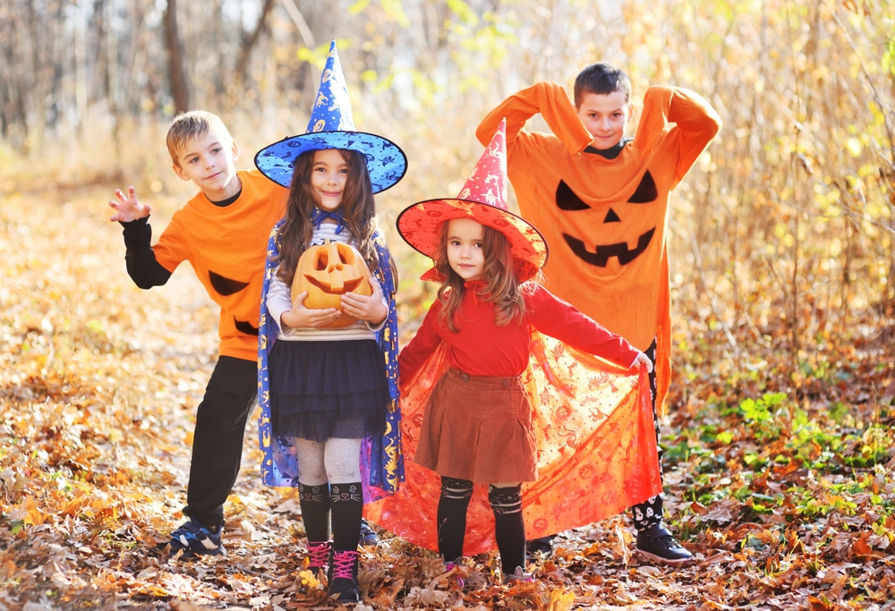 Children in Halloween costumes enjoying an autumn day outdoors