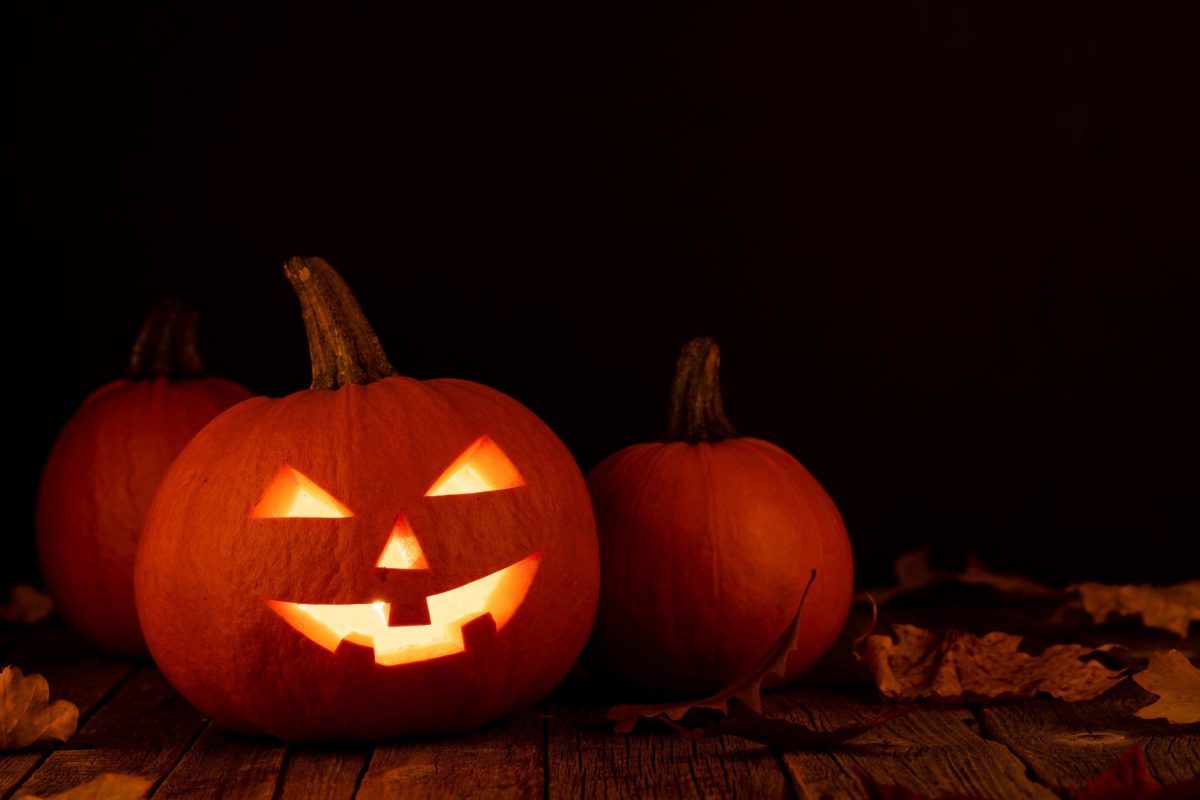 Two carved Halloween pumpkins glowing in the dark