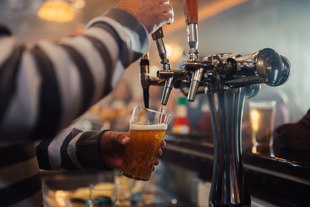 Hand holding a pint of beer in a traditional Dorset pub.