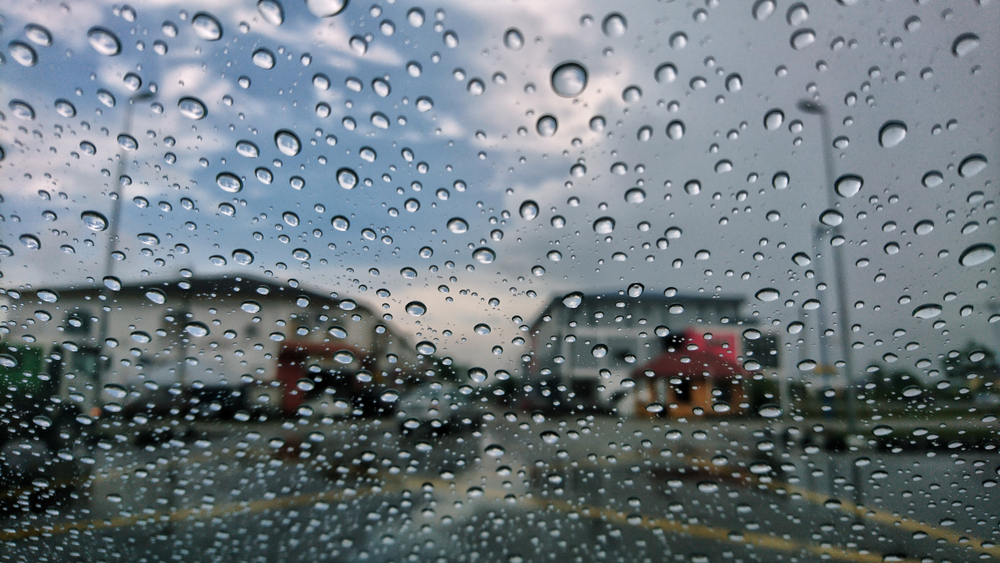 View through a rain-covered car windscreen on a wet, overcast day.